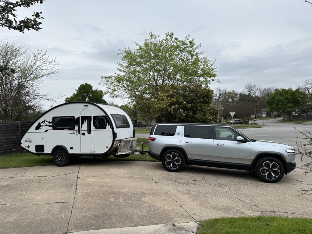 A silver SUV tows a teardrop trailer