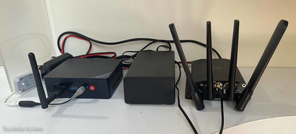 Three black boxes, bristling with antennas, with a bunch of wires between