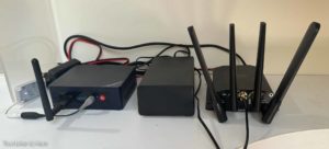 Three black boxes, bristling with antennas, with a bunch of wires between