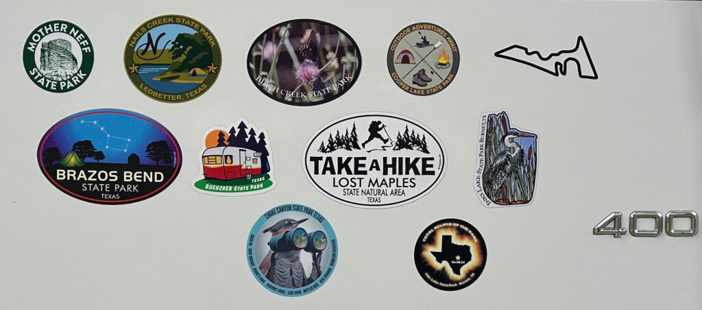 A selection of stickers from various Texas State Parks, including a Total Eclipse of the Park sticker from Inks Lake. There's also a Circuit of the Americas sticker.