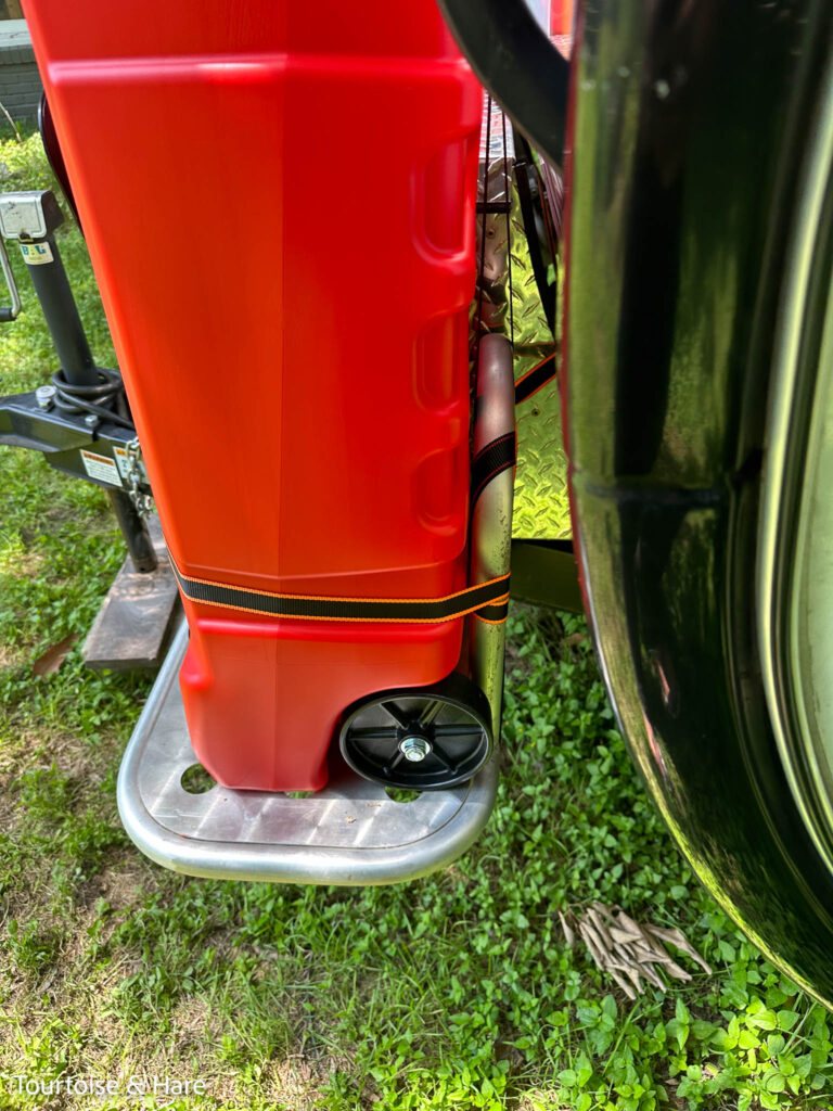 Side view, showing the ratchet strap going around the tank and around the aluminum tubing.